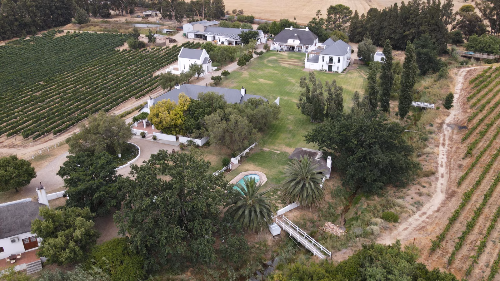 Manley Wine Estate — an aerial view of the estate's white Cape Dutch buildings among the vineyards