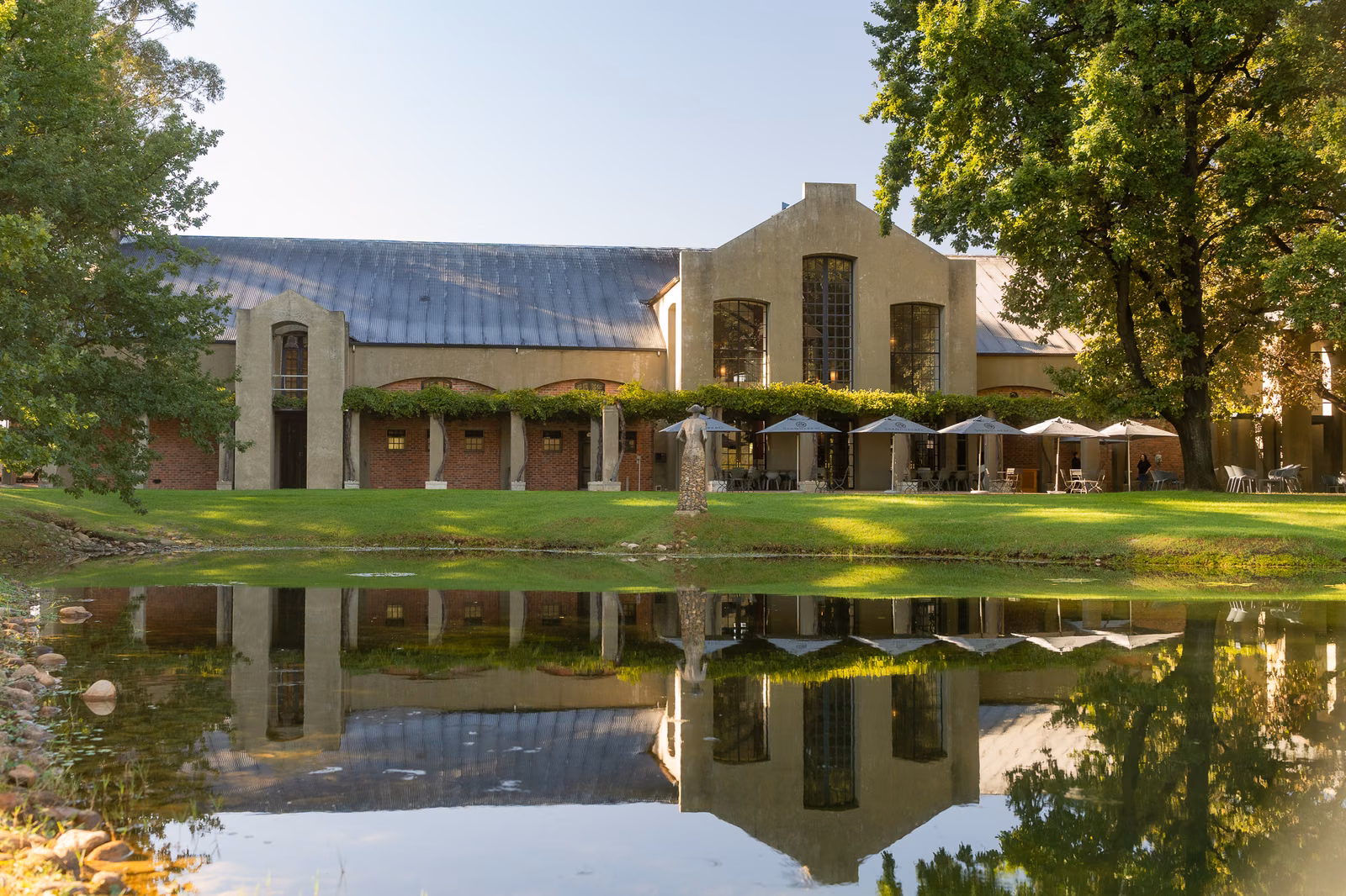 Saronsberg — the tasting room and its terrace umbrellas mirrored in the dam